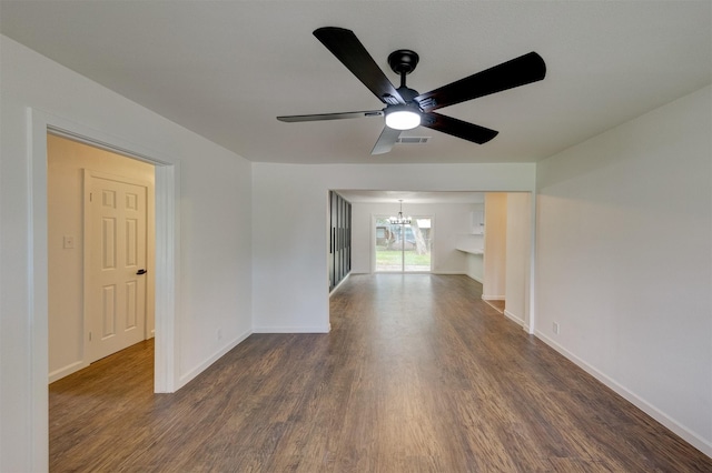 unfurnished room featuring dark hardwood / wood-style flooring and ceiling fan with notable chandelier