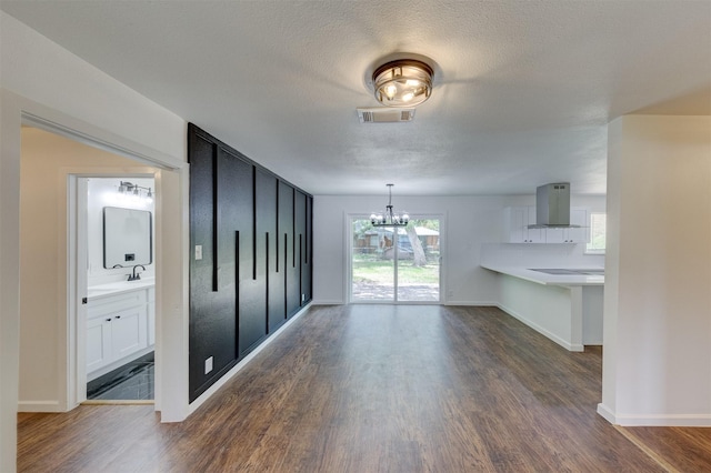 interior space with a chandelier, a textured ceiling, and dark wood-type flooring