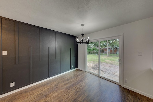 unfurnished dining area with hardwood / wood-style flooring and an inviting chandelier