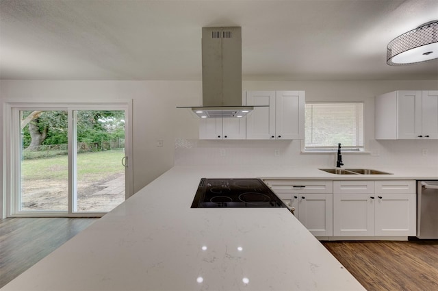 kitchen featuring island exhaust hood, stainless steel dishwasher, sink, hardwood / wood-style flooring, and white cabinets