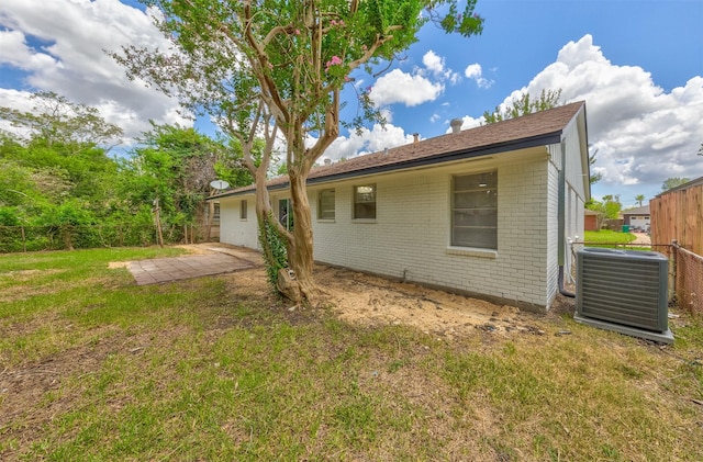 back of house with a yard and central AC