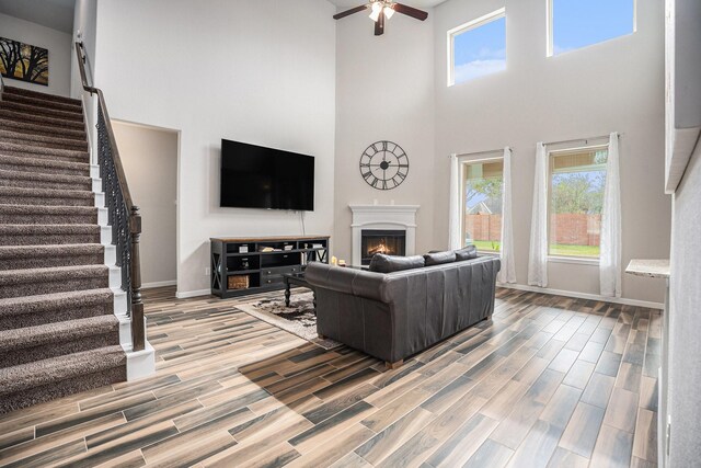 living room with ceiling fan and a towering ceiling