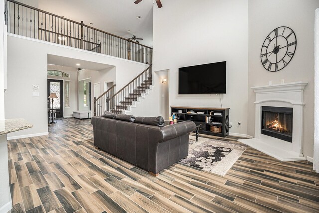 living room featuring ceiling fan and a high ceiling