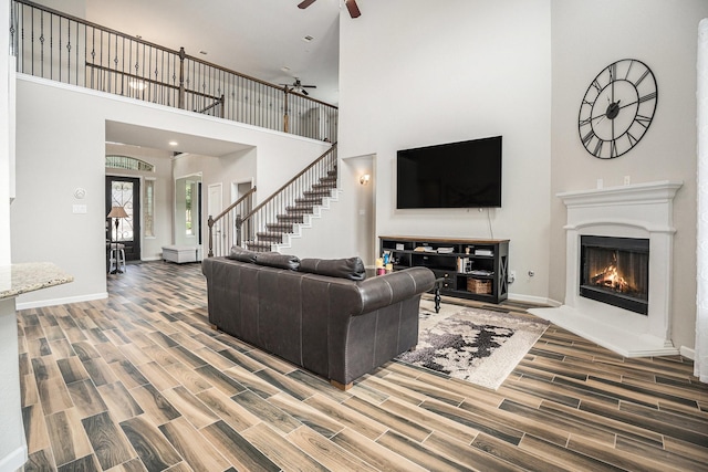 living room with ceiling fan and a high ceiling