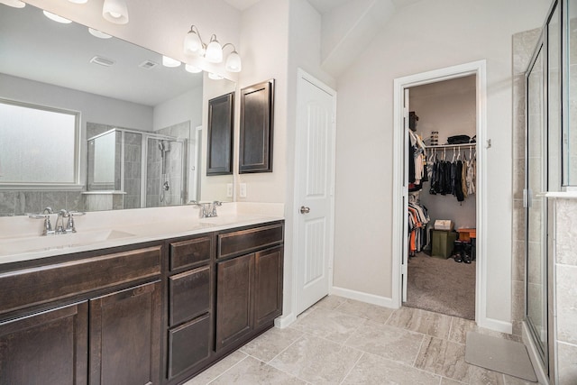 bathroom featuring a shower with shower door and vanity