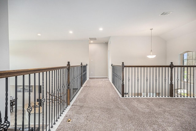 hallway featuring lofted ceiling and carpet flooring