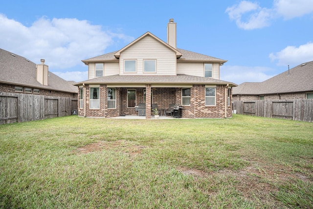 rear view of property featuring a yard and a patio