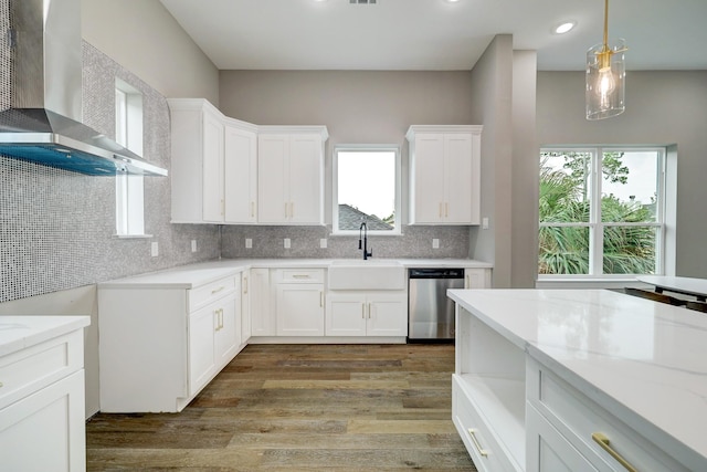 kitchen with white cabinetry, hardwood / wood-style floors, wall chimney exhaust hood, and dishwasher