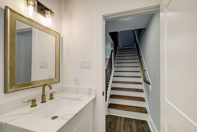 stairway with wood-type flooring and sink