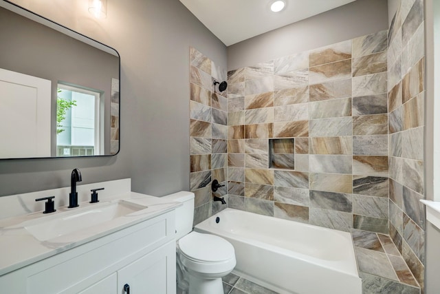 full bathroom featuring tiled shower / bath, vanity, and toilet