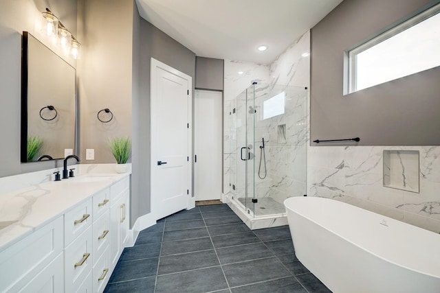 bathroom with tile patterned flooring, vanity, tile walls, and plus walk in shower