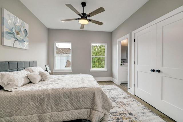 bedroom featuring ceiling fan, wood-type flooring, and sink