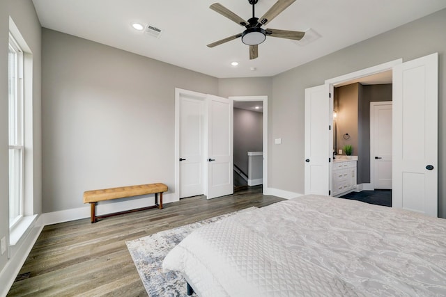 bedroom featuring multiple windows, hardwood / wood-style floors, and ceiling fan