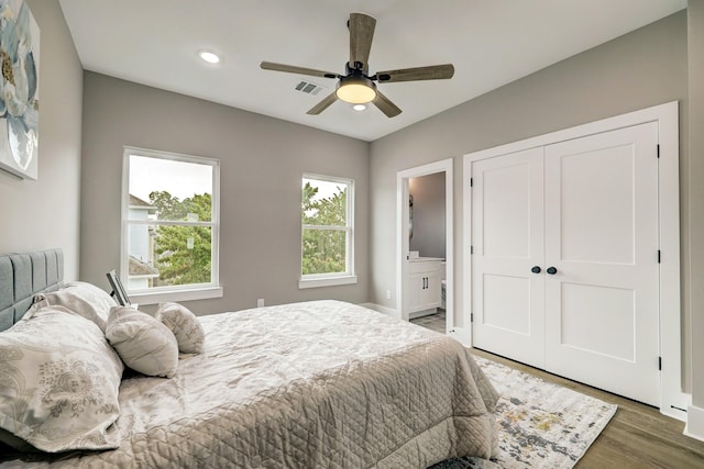 bedroom featuring dark wood-type flooring, ceiling fan, connected bathroom, and a closet