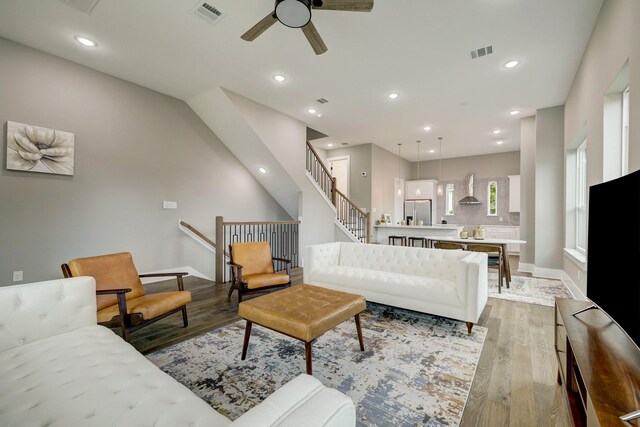 living room with light hardwood / wood-style flooring and ceiling fan