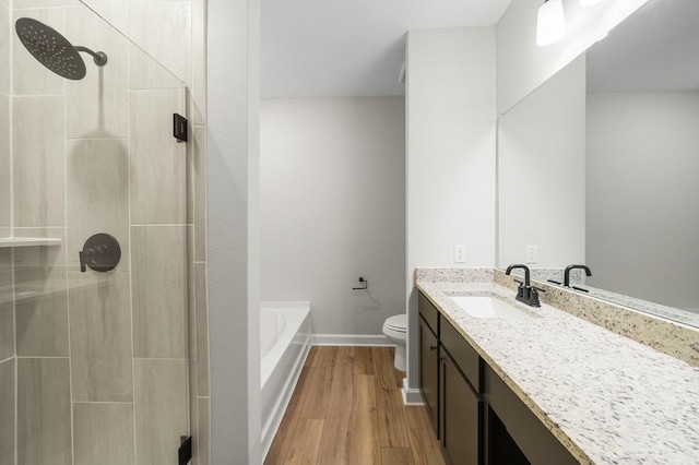 full bathroom with separate shower and tub, toilet, vanity, and hardwood / wood-style flooring