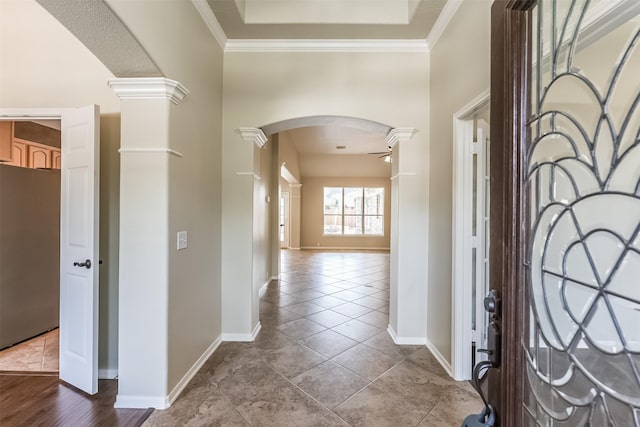 foyer featuring ornate columns, ornamental molding, and light tile patterned floors