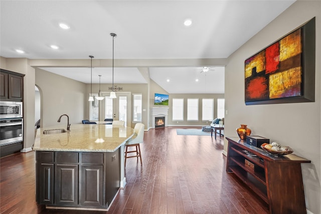 kitchen featuring a center island with sink, sink, ceiling fan, a wealth of natural light, and appliances with stainless steel finishes