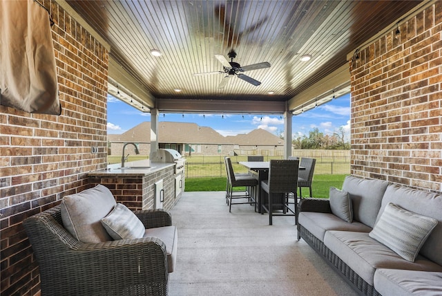 view of patio featuring ceiling fan, sink, an outdoor kitchen, an outdoor hangout area, and area for grilling