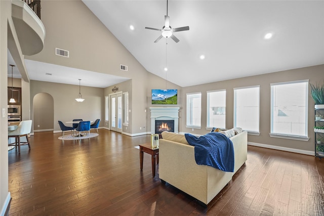 living room featuring a high ceiling, dark hardwood / wood-style floors, and ceiling fan