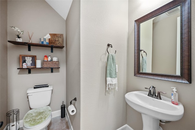 bathroom featuring sink, vaulted ceiling, and toilet