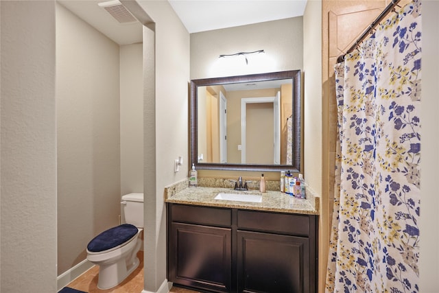 bathroom featuring tile patterned floors, vanity, toilet, and walk in shower