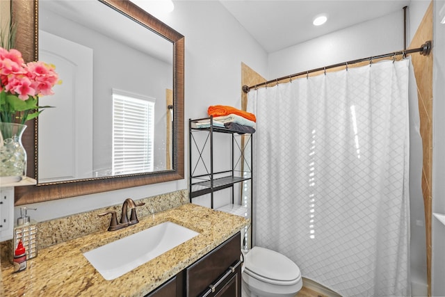 bathroom with vanity, toilet, and curtained shower