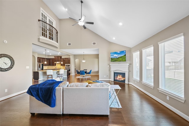 living room featuring ceiling fan, sink, high vaulted ceiling, and dark hardwood / wood-style floors