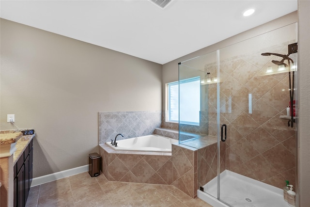 bathroom featuring plus walk in shower, vanity, and tile patterned floors