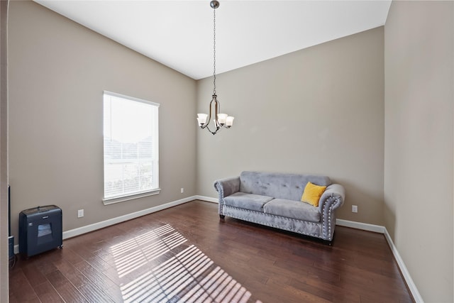 sitting room with a chandelier and dark wood-type flooring