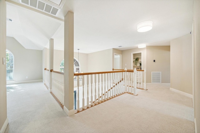 hallway with light carpet and lofted ceiling