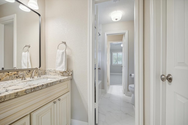 bathroom with toilet, ceiling fan, and vanity