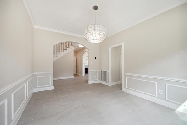 tiled spare room with a notable chandelier and crown molding