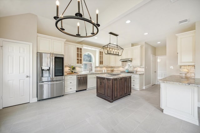 kitchen featuring stainless steel appliances, light tile patterned floors, backsplash, light stone countertops, and pendant lighting