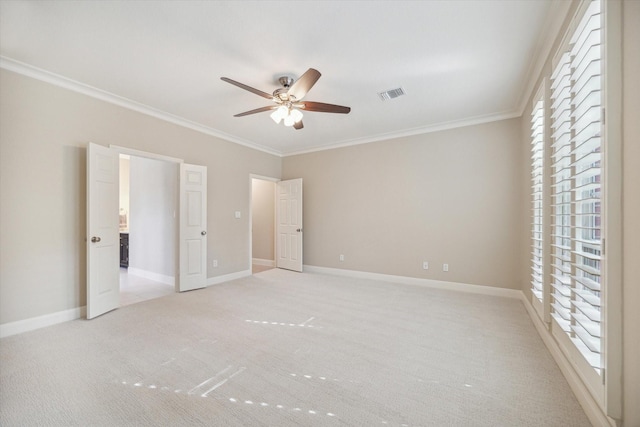 unfurnished bedroom featuring light colored carpet, ceiling fan, and crown molding