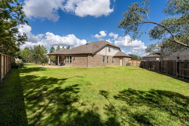 back of house featuring a lawn and a patio area