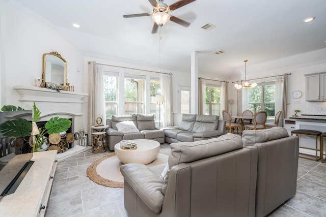 living room with a wealth of natural light and ceiling fan with notable chandelier