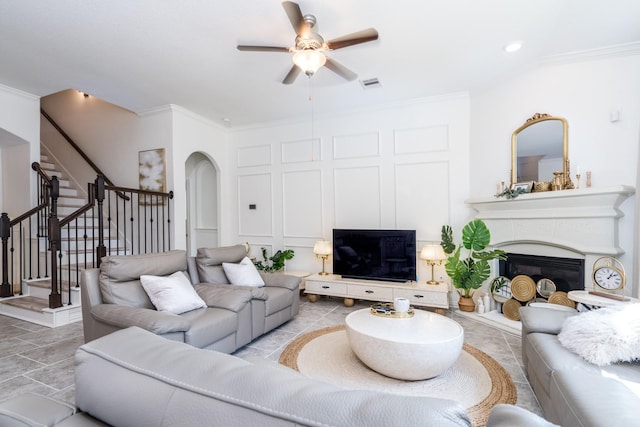 living room featuring ceiling fan and crown molding