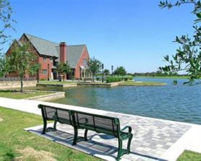 view of property's community with a yard and a water view