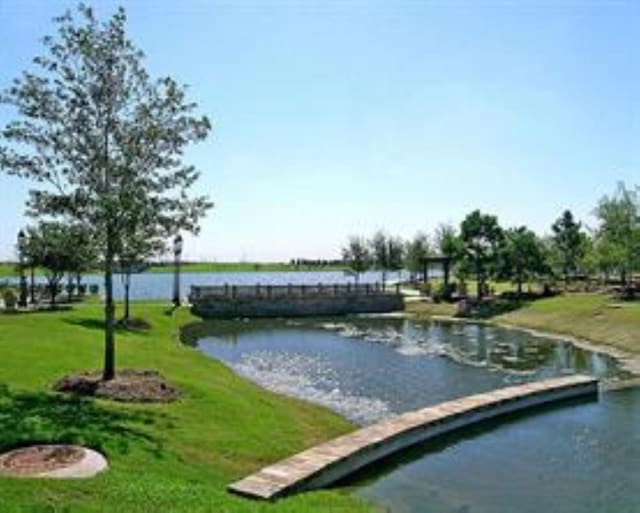 surrounding community featuring a yard and a water view