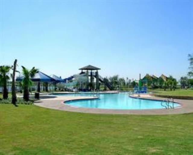 view of swimming pool featuring a yard