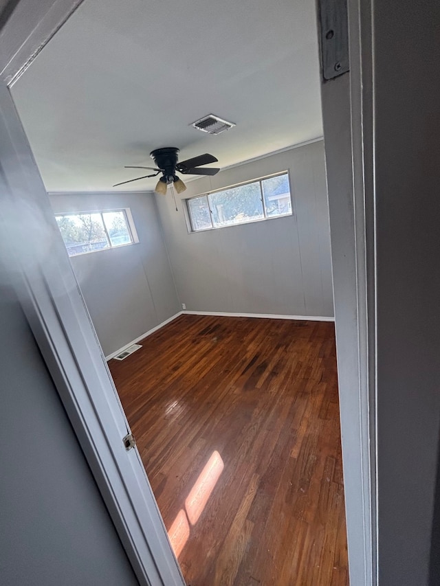 unfurnished room with ceiling fan and dark wood-type flooring