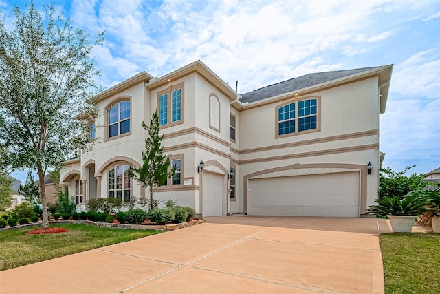 mediterranean / spanish-style house with a garage and a front lawn