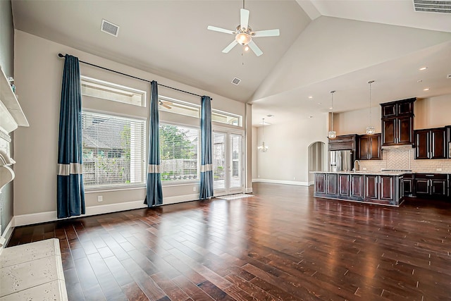 unfurnished living room featuring high vaulted ceiling, ceiling fan, and dark wood-type flooring