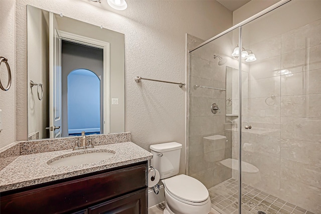 bathroom with vanity, an enclosed shower, and toilet