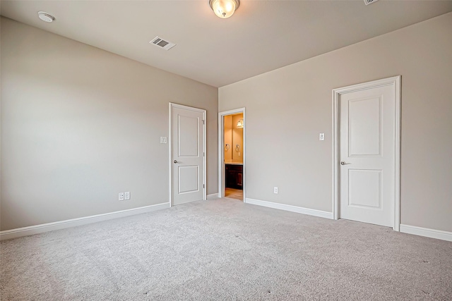 unfurnished bedroom with light colored carpet and ensuite bath