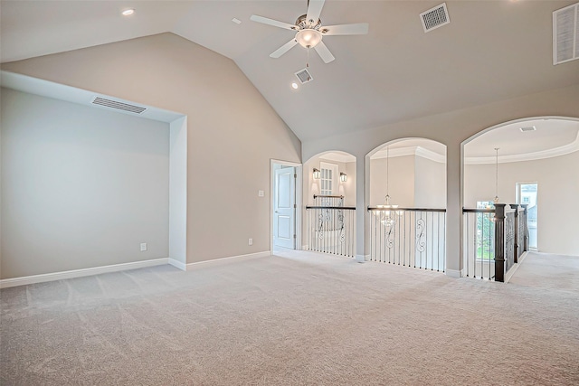 empty room with light carpet, ceiling fan with notable chandelier, and high vaulted ceiling