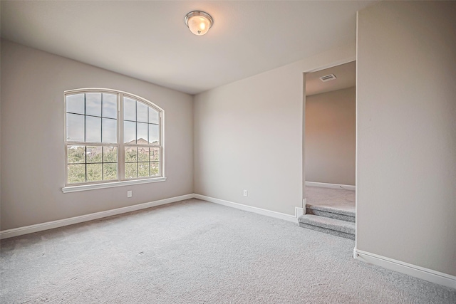 unfurnished room featuring light carpet