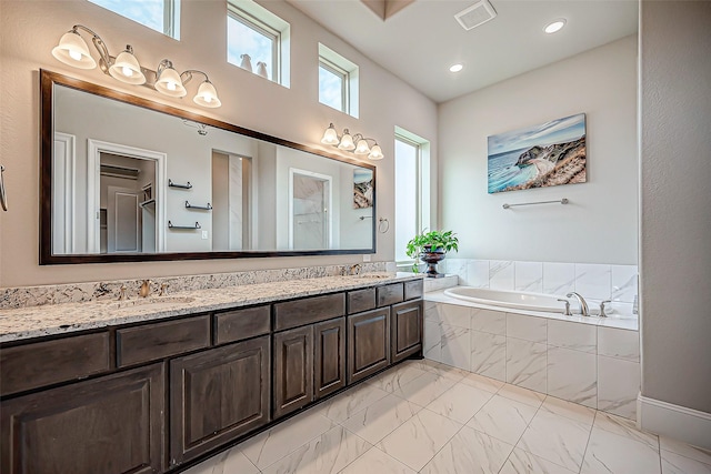 bathroom featuring vanity and tiled tub