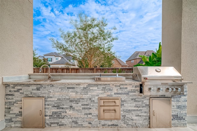 view of patio with an outdoor kitchen, sink, and grilling area